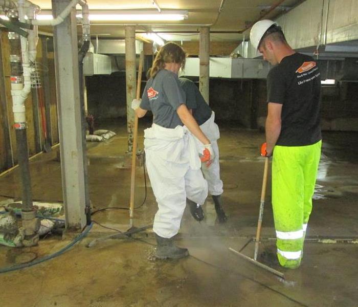 crew cleaning up water in the basement