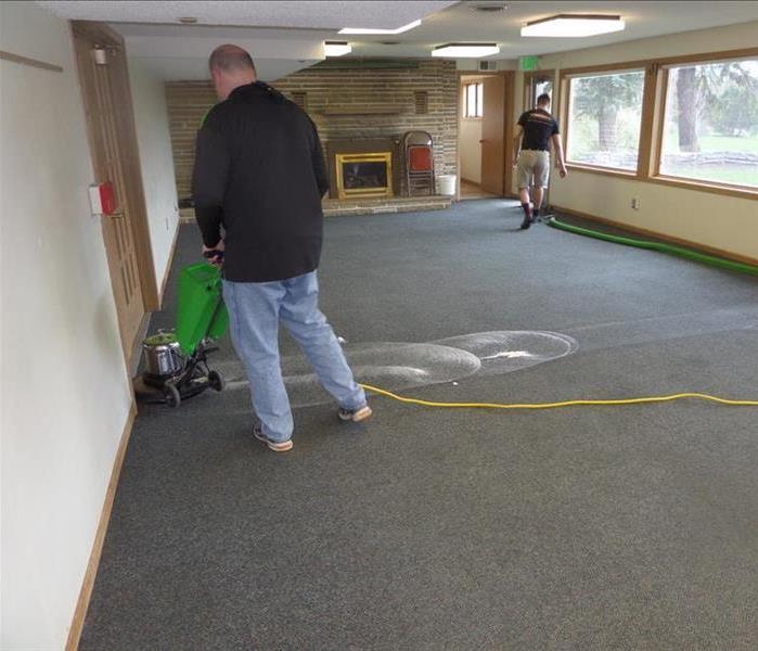 two men cleaning a carpet